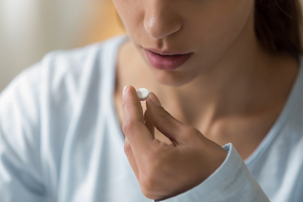 Vrouw neemt pijnstiller